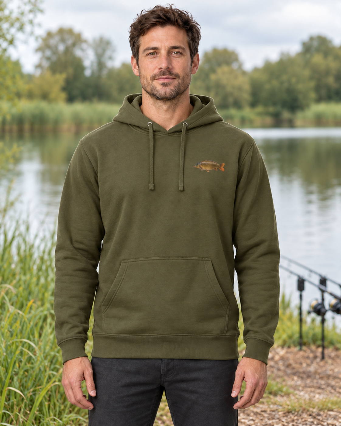 Front view of a model wearing the Military Green carp hoodie beside a lake